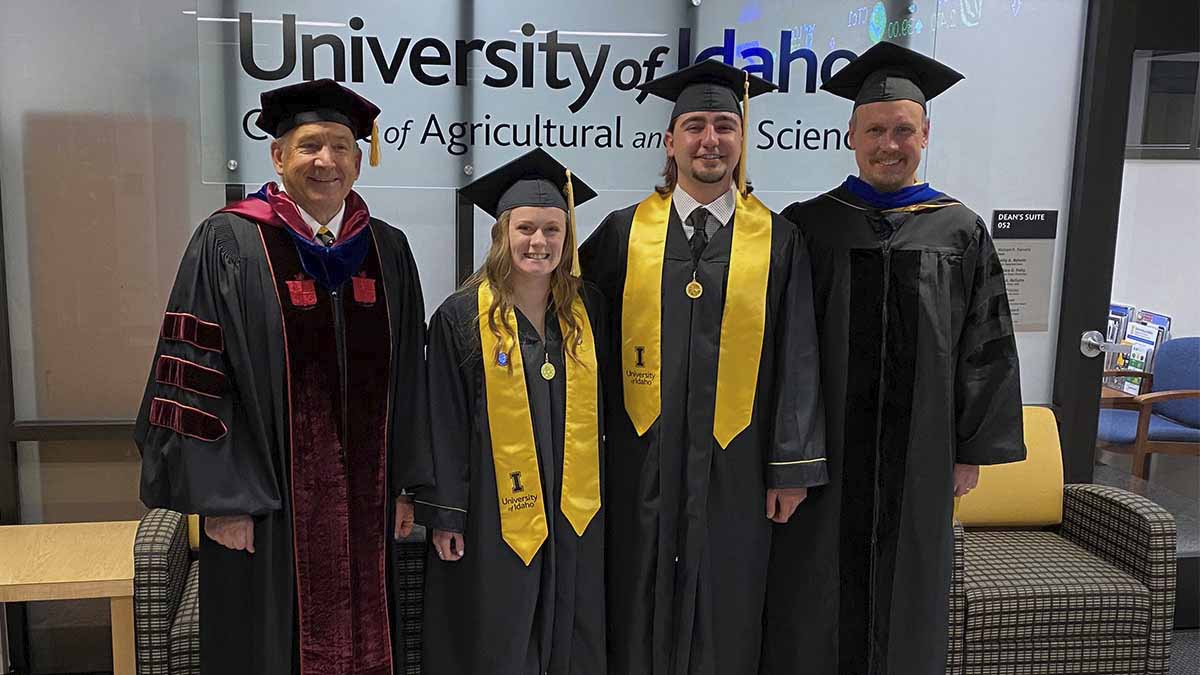 Group of faculty and students in graduation caps and gowns.