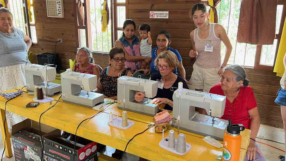 Women in a room with sewing machines.
