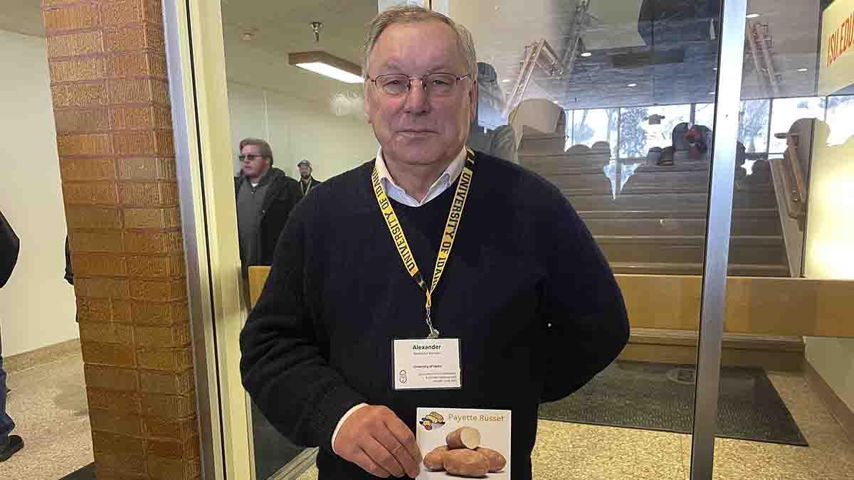 A portrait of a man holding a card.