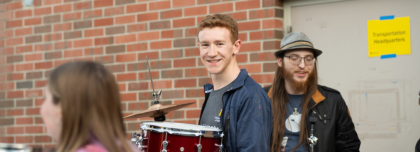 Boy carrying drum set.