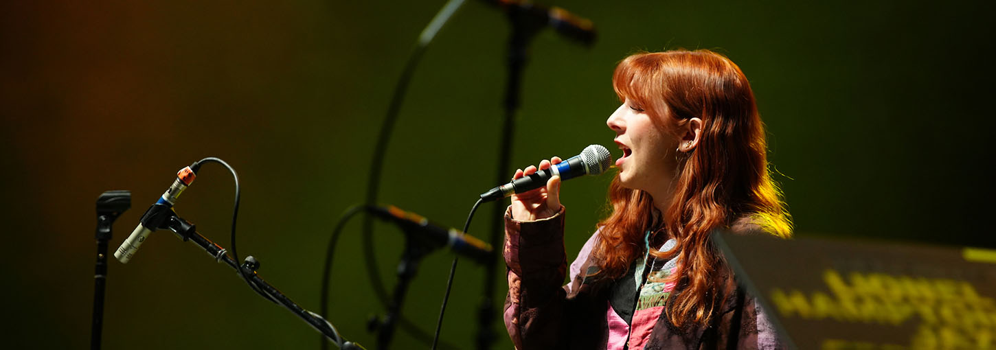 Woman singing on stage with microphone