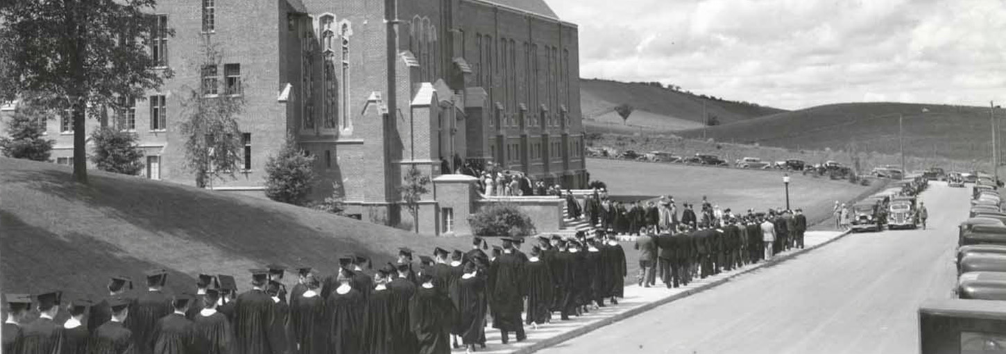 Black and white photo of students walking to the memorial gym for graduation