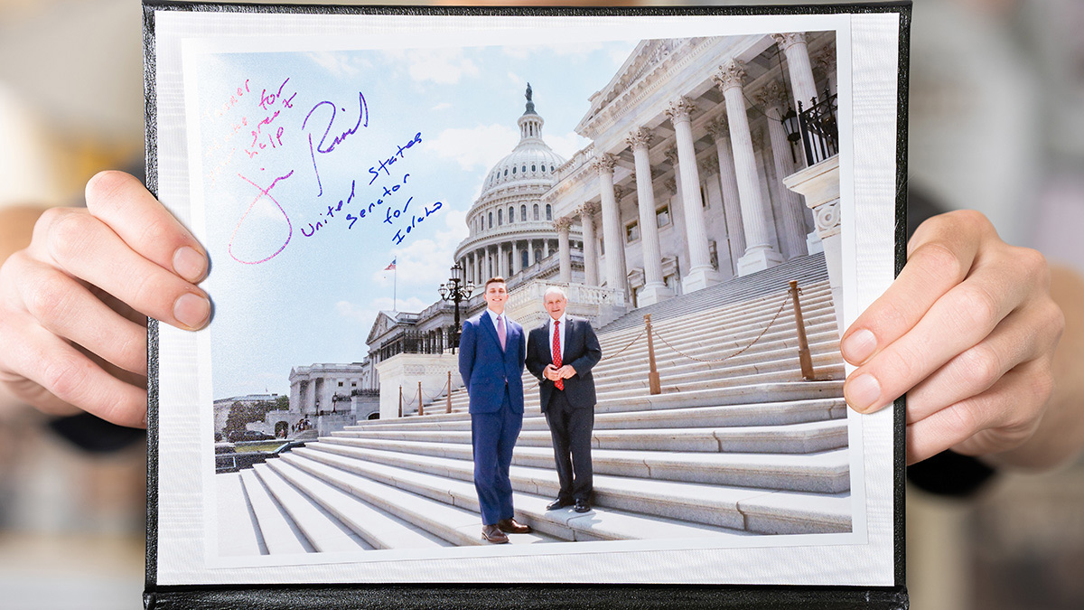 Two hands hold picture and plaque.