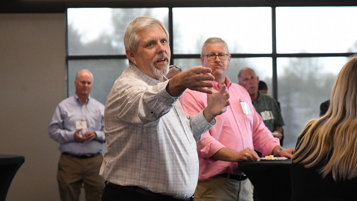 A man in a white button up shirt pointing at a lady during a discussion